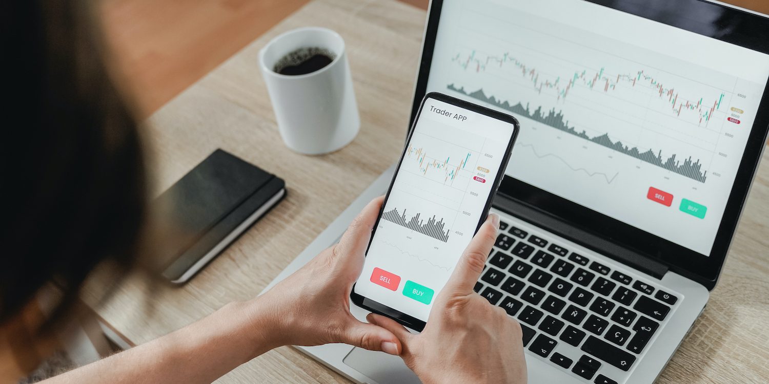 Forex trader using crypto exchange mobile phone app for investment and stock market analysis at hedge fund office – Focus on screen